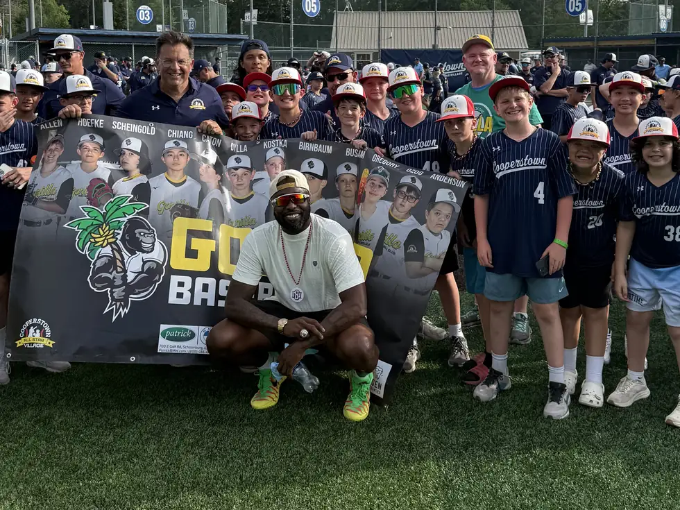 The Gorilla Baseball Club 12U team with their banner and 2003 World Series champion Dontrelle Willis at Cooperstown All Star Village