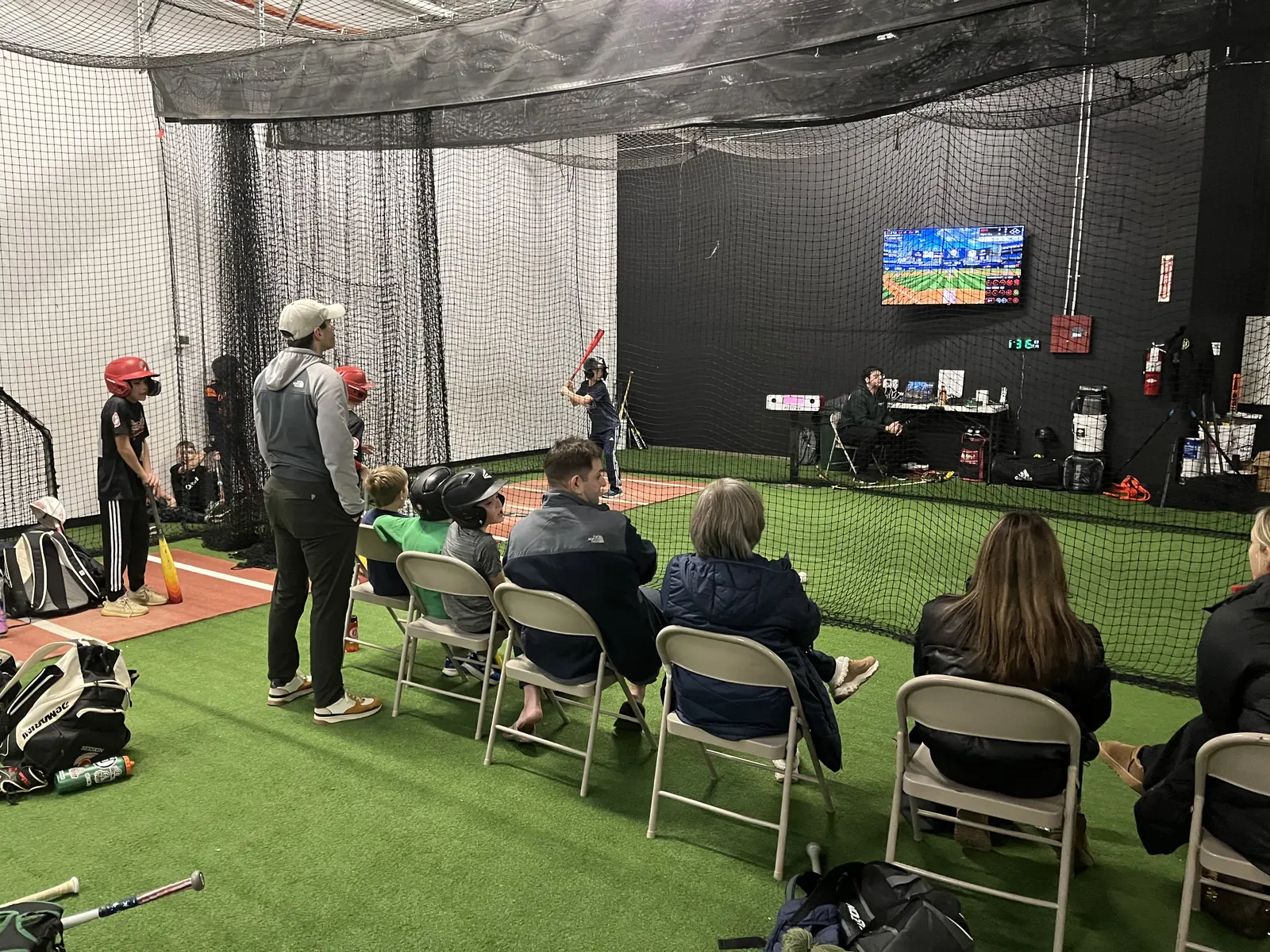 A Saturday hitting league game on HitTrax, with parents watching