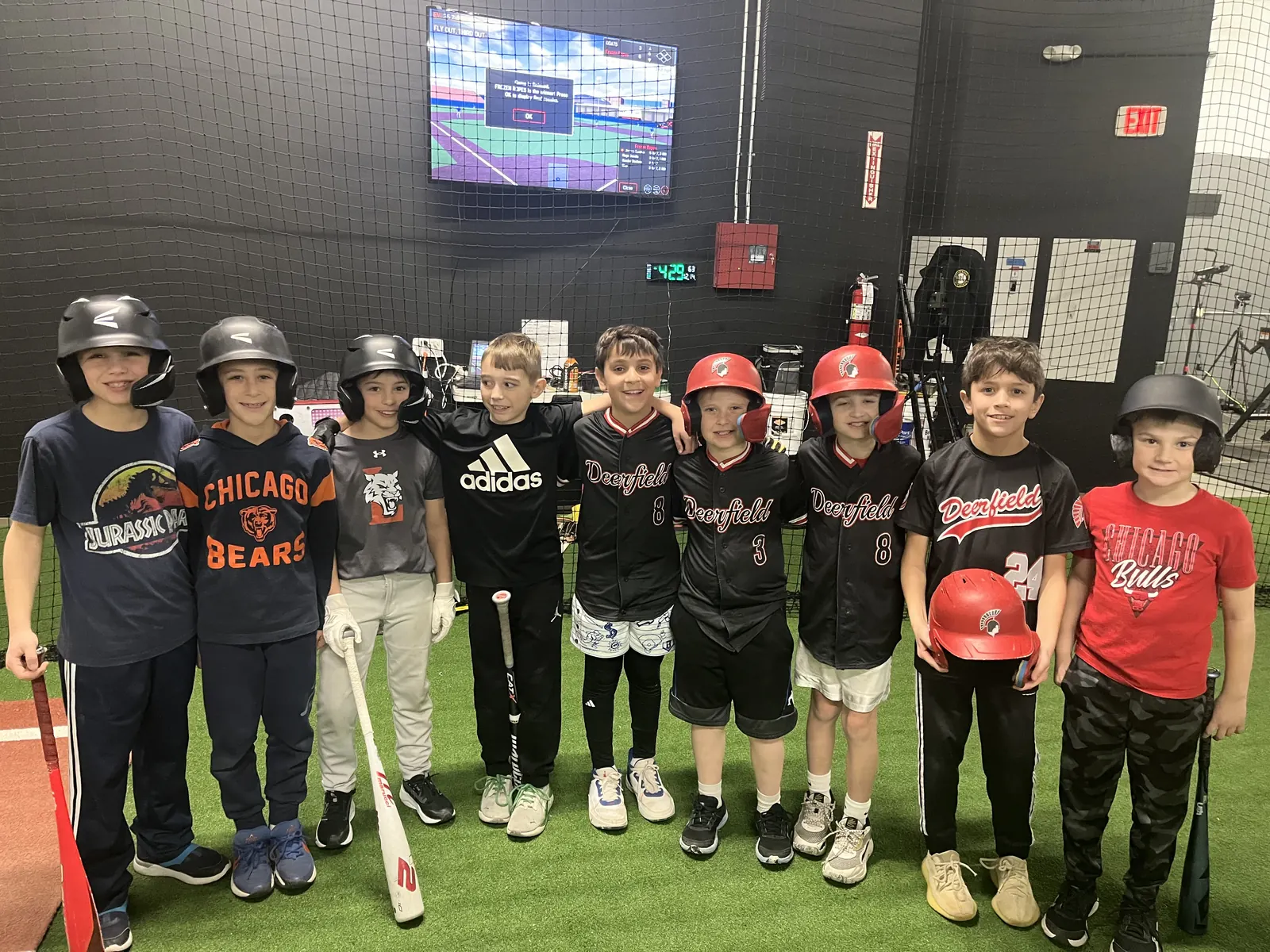 Hitting league players lined up in front of the HitTrax screen