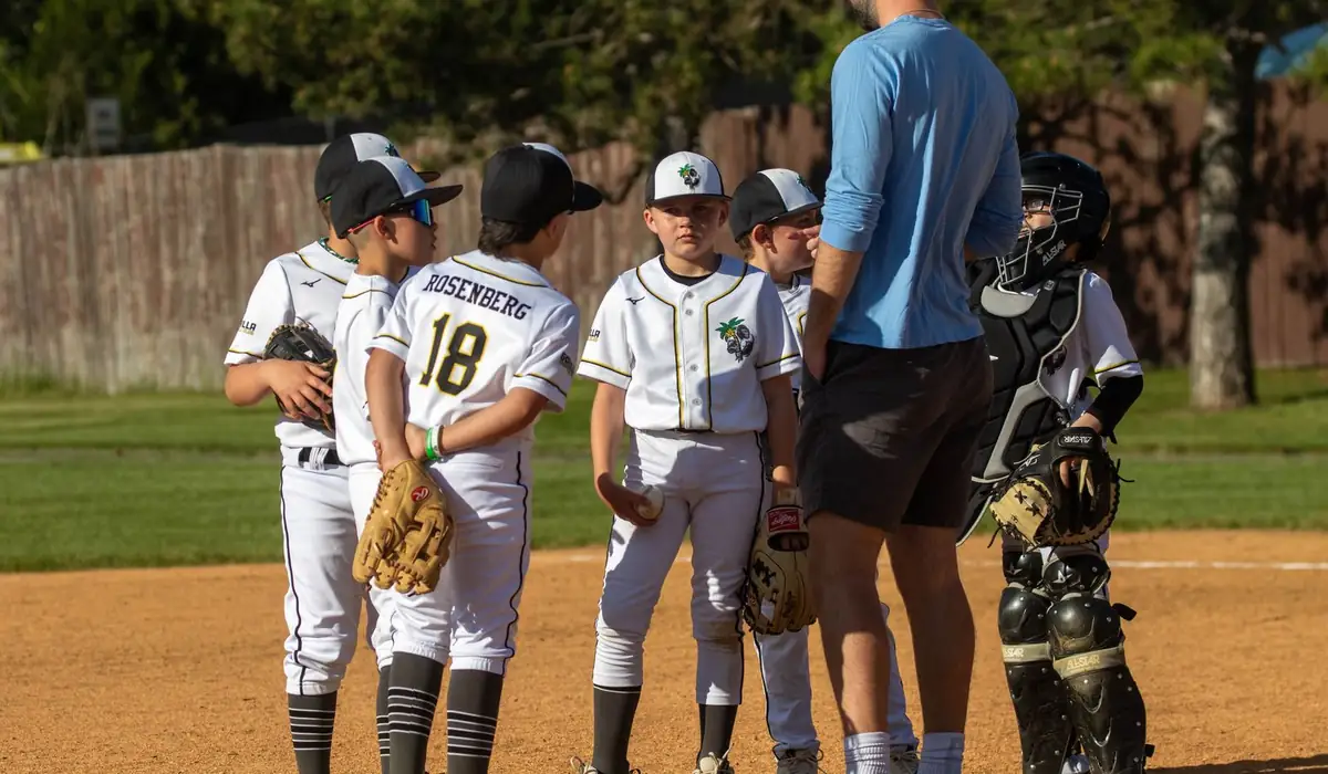 A Gorilla coach talking with his infielders and catcher on the mound